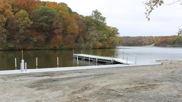 shore, dock and lake with colorful fall trees in background