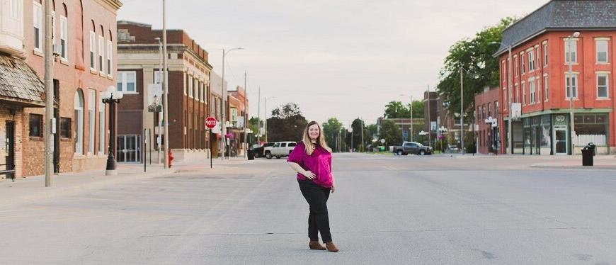 woman stands in the street in downtown Aledo