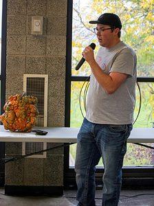 livestock judging team member with microphone in front of pumpkin on table
